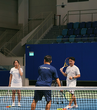 Tennis coach demonstrating forehand technique during lesson